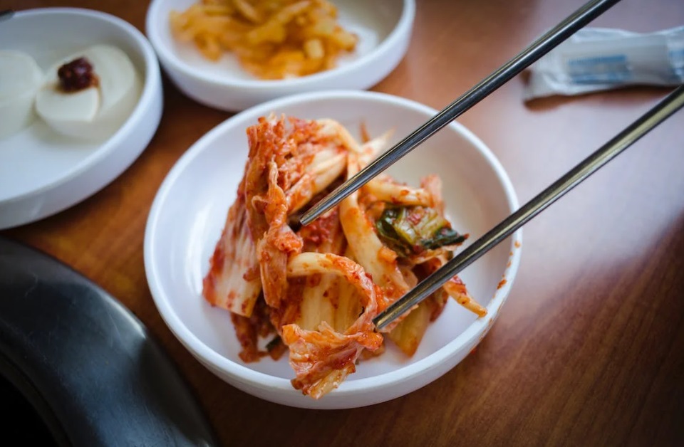 A jar of homemade kimchi with napa cabbage, radish, and scallions
